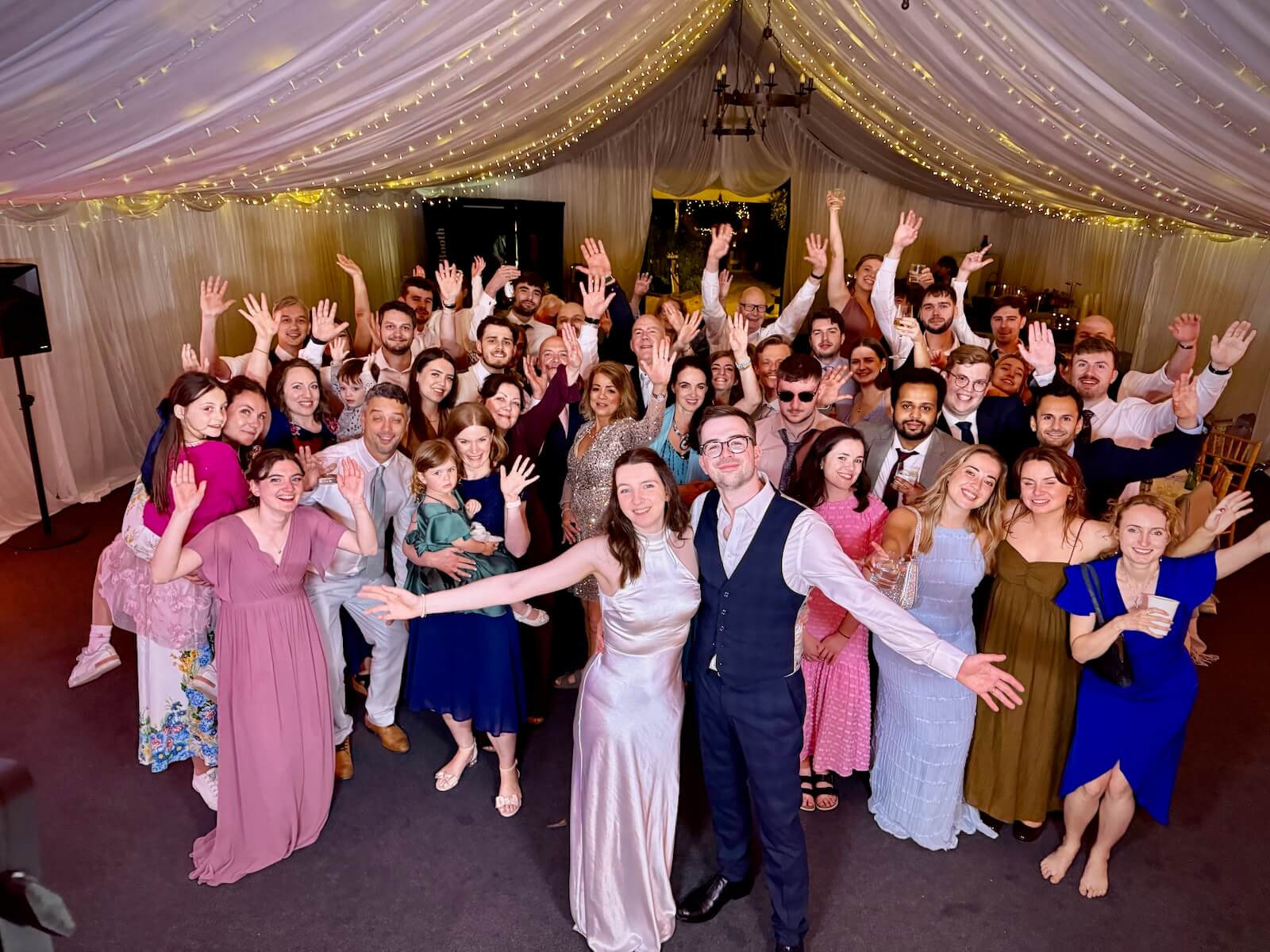 Kate and Tom at the end of their wedding party with all their guests