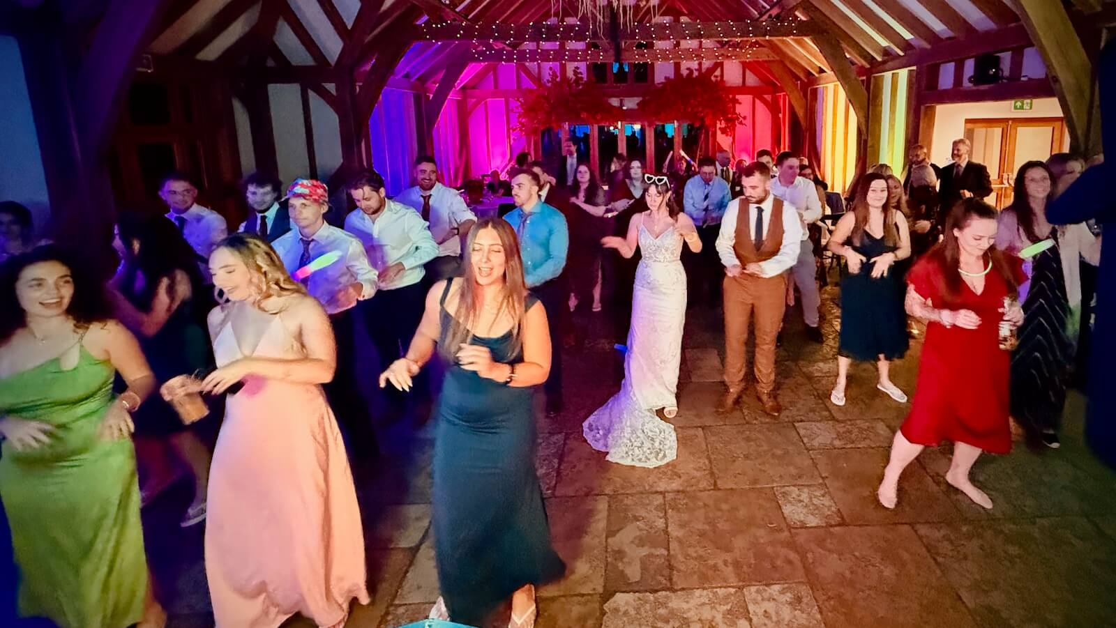 Guests dancing during Alex and Jo’s wedding party at Brookfield Barn in West Sussex