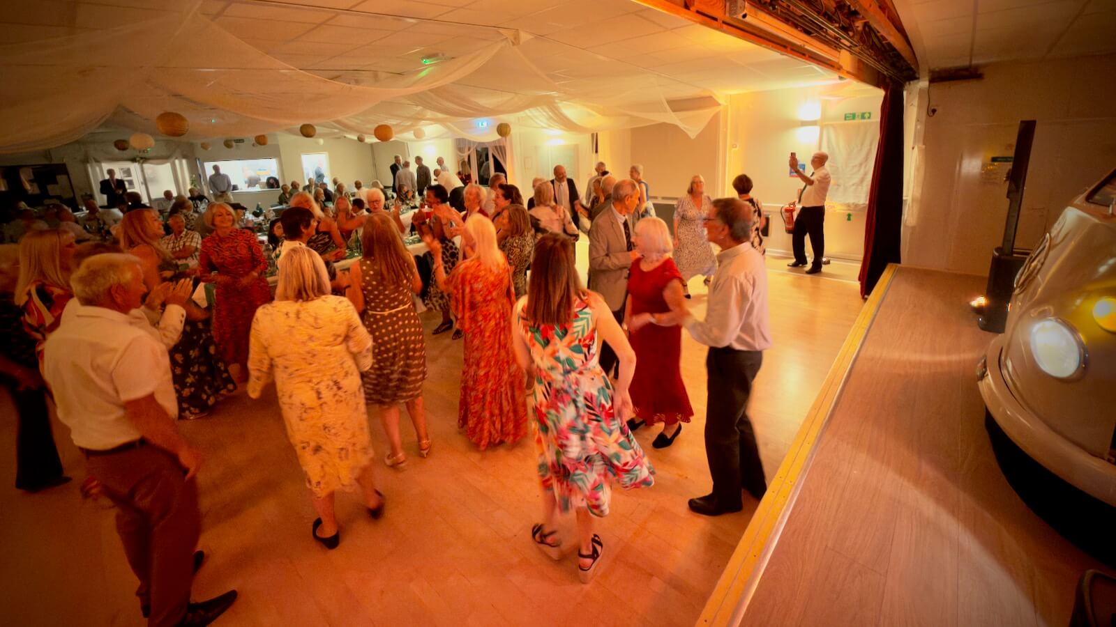 guests dancing at Gail and Simon's wedding at Bramshaw Village Hall in the New Forest, 26th September 2026 with DJ Brian Mole and the VW DJ booth