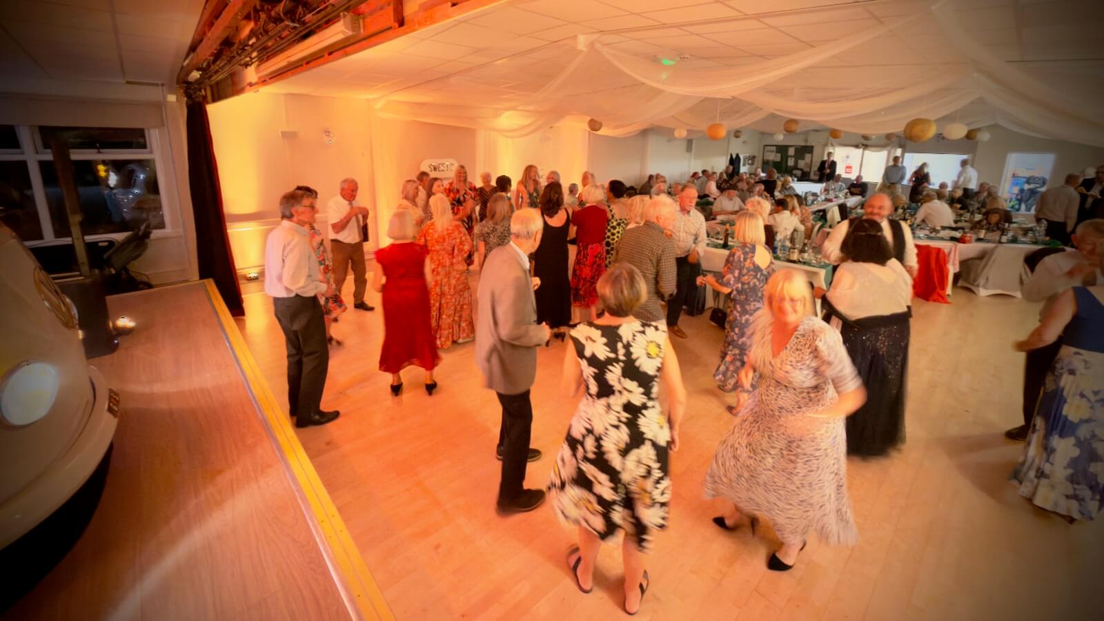 guests dancing at Gail and Simon's wedding at Bramshaw Village Hall in the New Forest, 26th September 2026 with DJ Brian Mole and the VW DJ booth